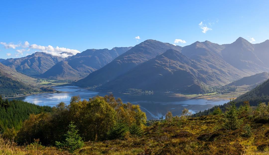 Helicopter flying over the Five Sisters of Kintail in the Scottish Highlands